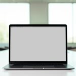 An open laptop computer sitting on a bright white desk