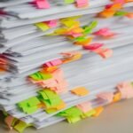 Stack of documents with colorful sticky note tabs, illustrating AI-powered document summarization
