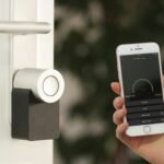 Smart door lock controlled from an iPhone app, illustrating Matter-compatible smart home devices