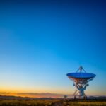 Satellite dish in a rural field at sunset, illustrating satellite internet for rural connectivity