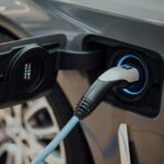Electric vehicle charging cable plugged into a car, illustrating the state of EVs this year
