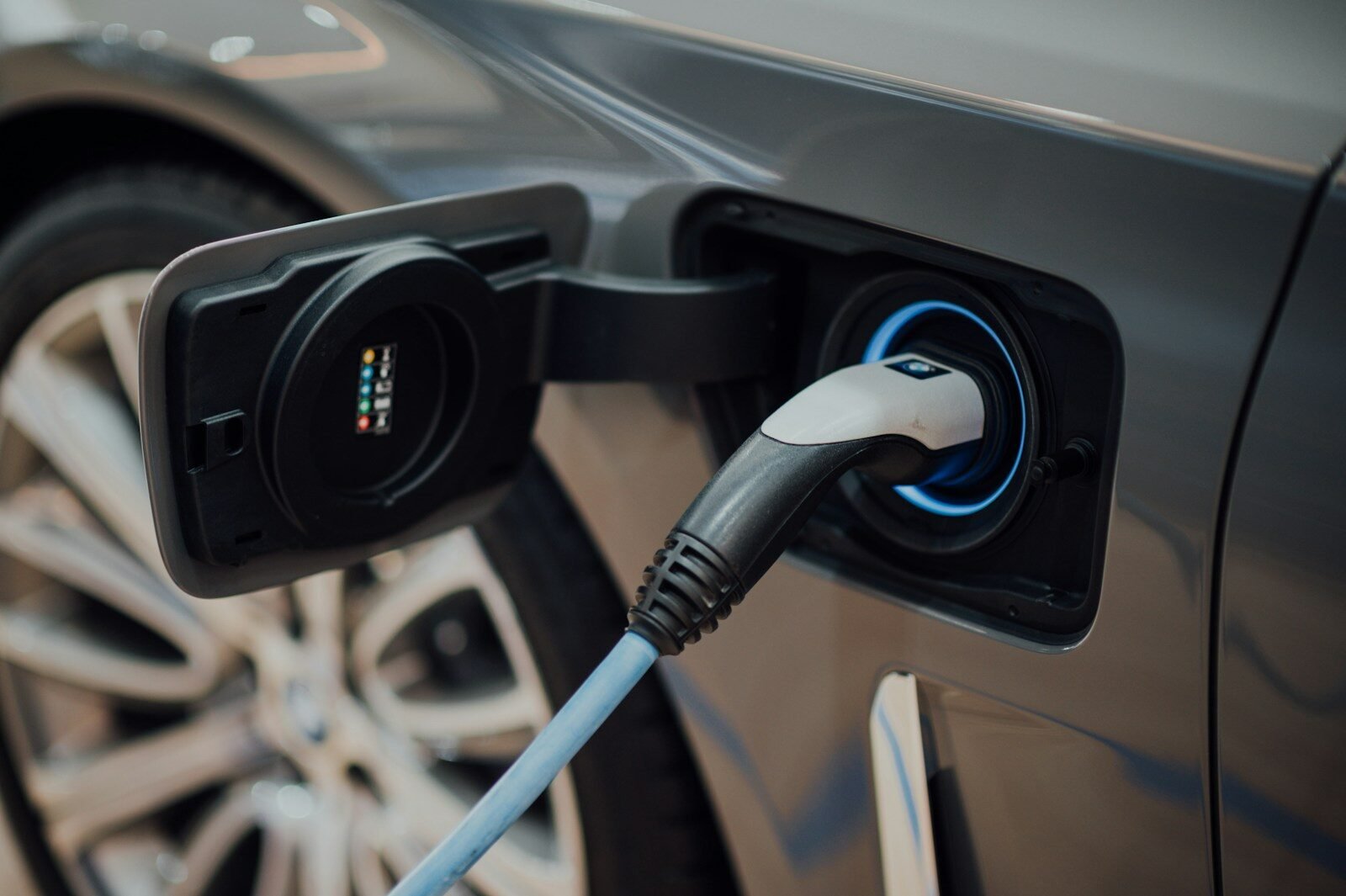 Electric vehicle charging cable plugged into a car, illustrating the state of EVs this year