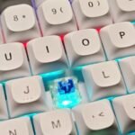 Close-up of a white mechanical keyboard with blue switches and white keycaps, illustrating a beginner guide to mechanical keyboards